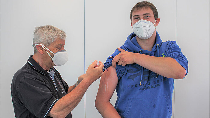 Die erste Impfung in der Unternehmenszentrale WI.com in Spangenberg verabreichte Betriebsarzt Dr. Christoph Brückner dem Mitarbeiter Janek Zieba 
